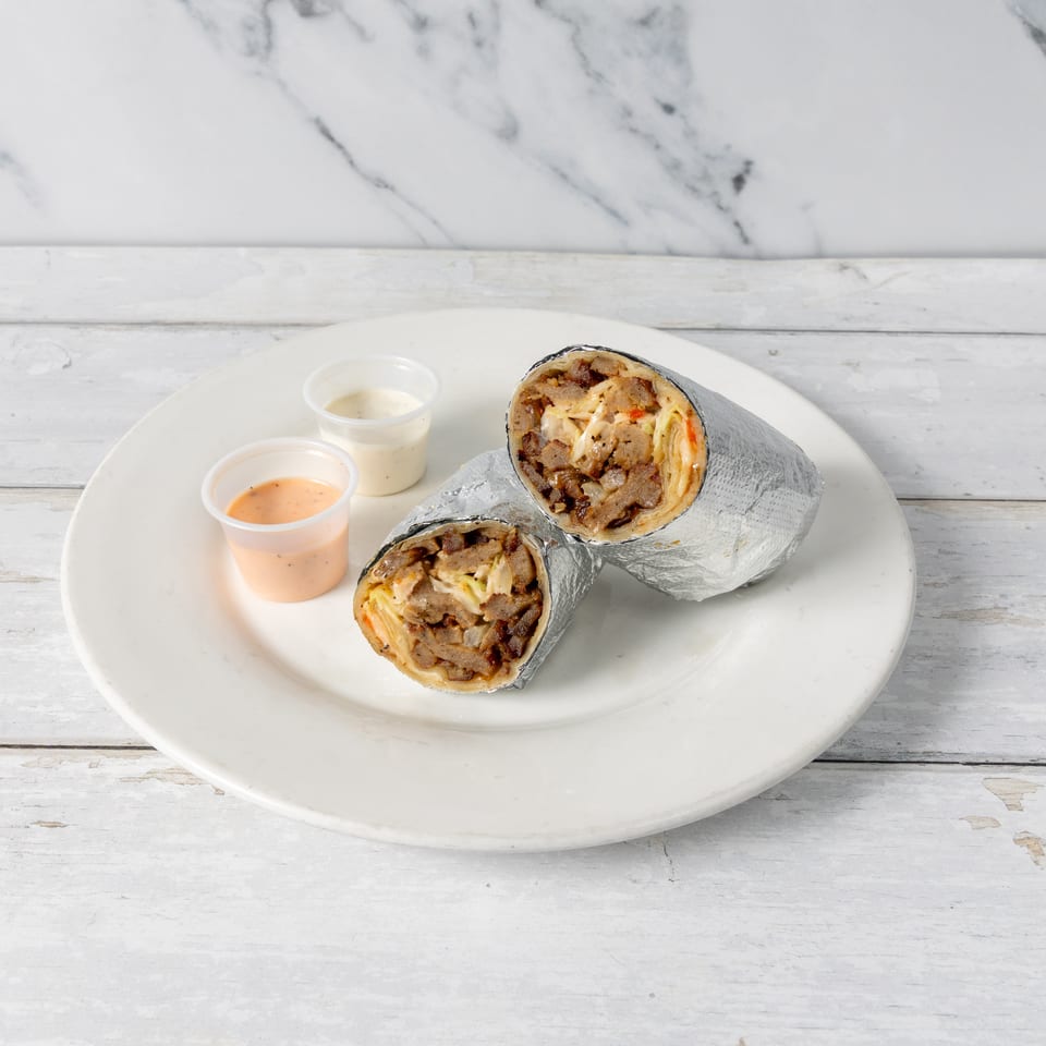 Two foil-wrapped shawarma wraps with meat and vegetables, served with two dipping sauces on a white plate.